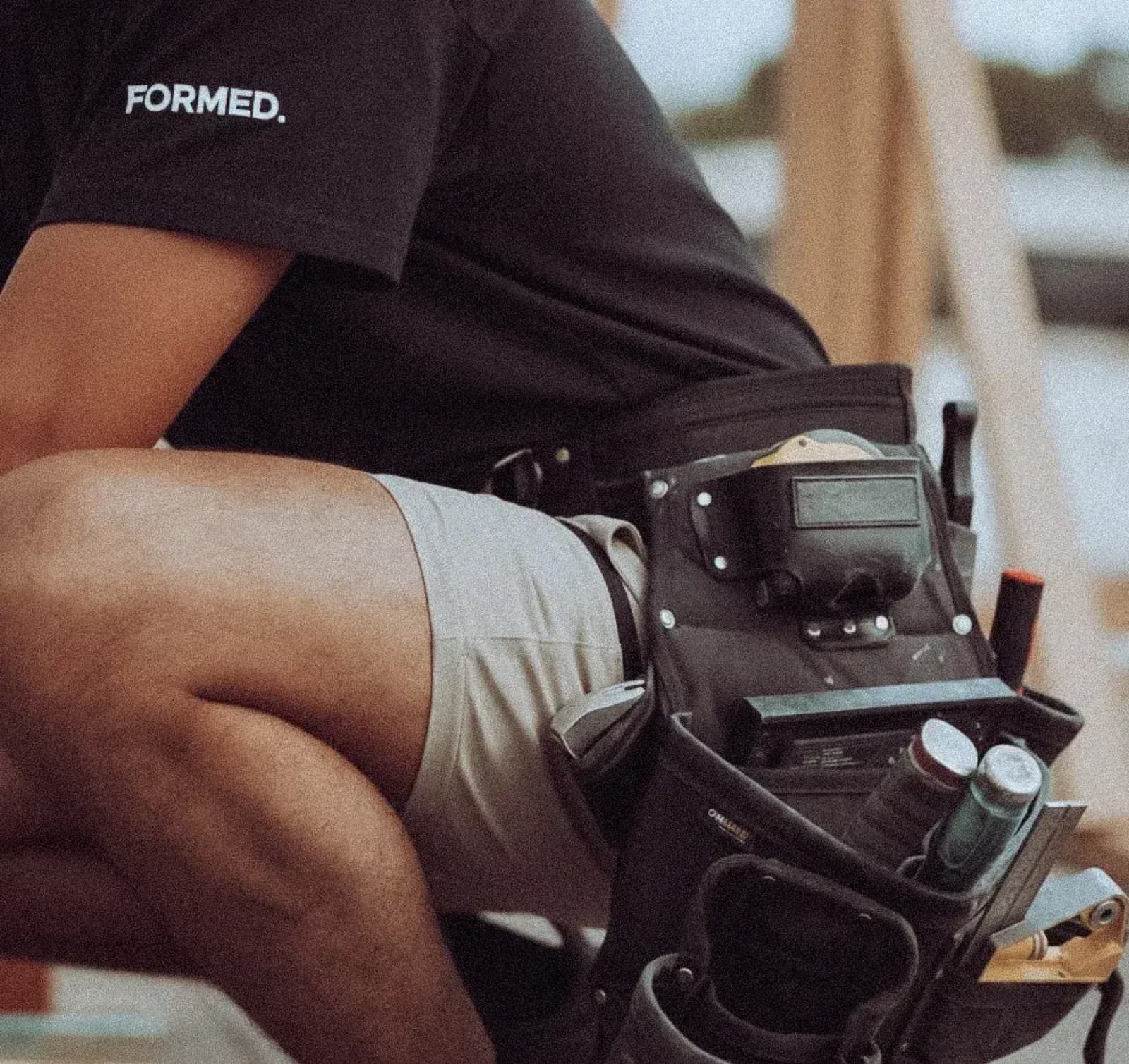 Formed Carpentry worker with tool belt on a commercial job site