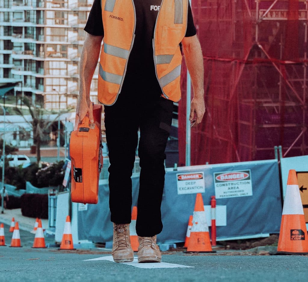 Carpenter walking through commercial construction site at golden hour